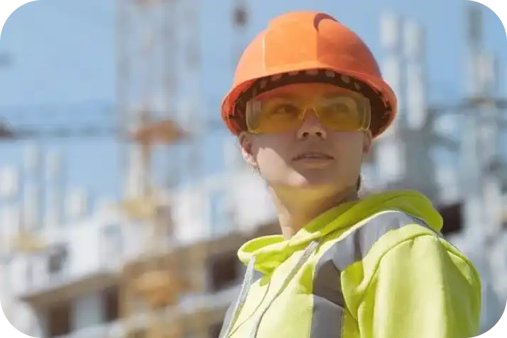 Female construction site worker in safety gear ensuring security and safety compliance.