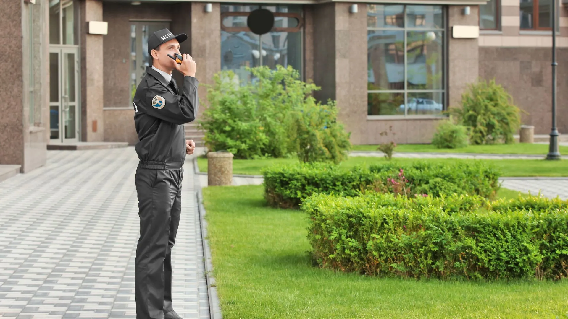 An unarmed security guard patrolling an outdoor area near a building, ensuring safety and maintaining a secure environment.