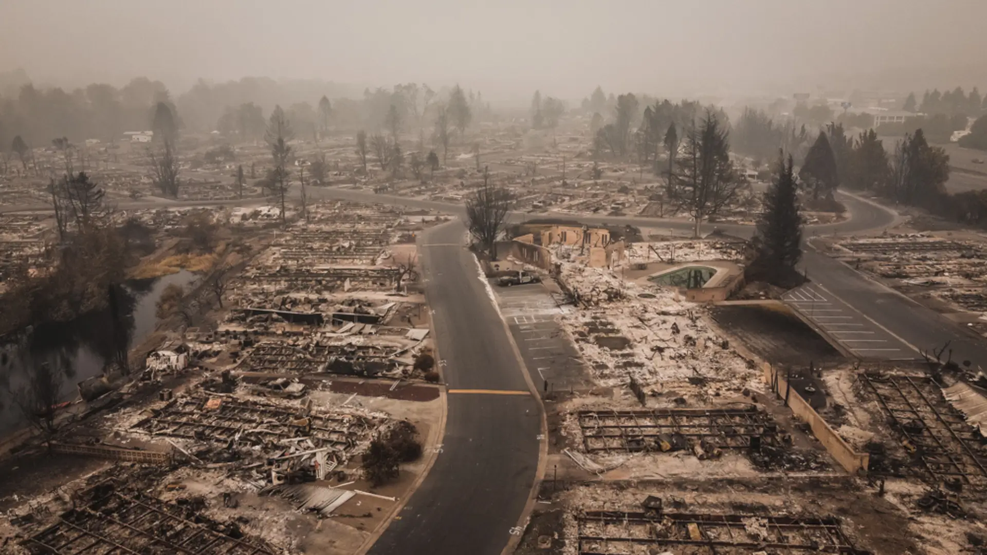 Aftermath of a wildfire showing a devastated neighborhood, emphasizing the importance of fire watch security in preventing such destruction.