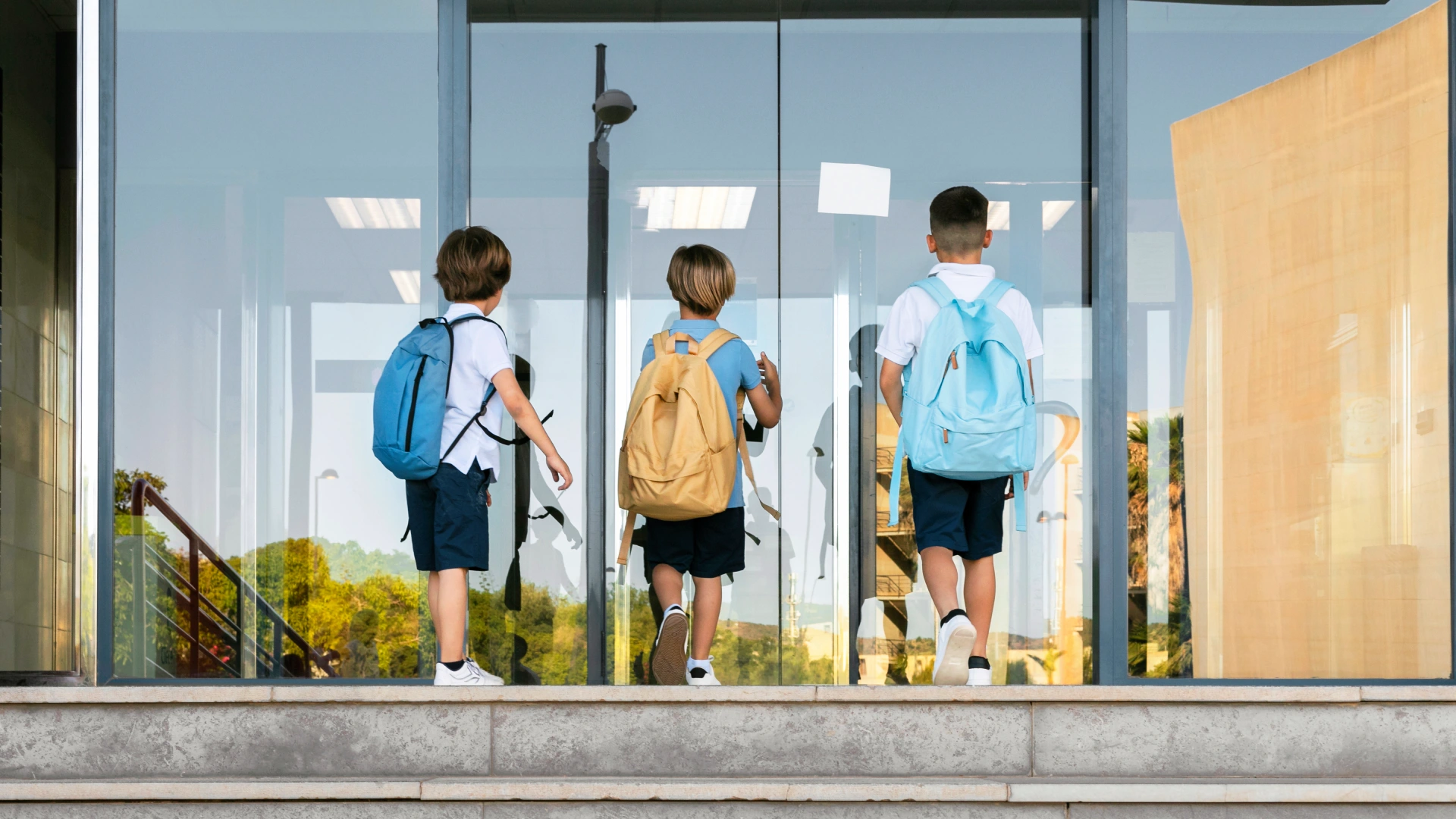 Three young students entering a secure school building, representing school safety efforts.