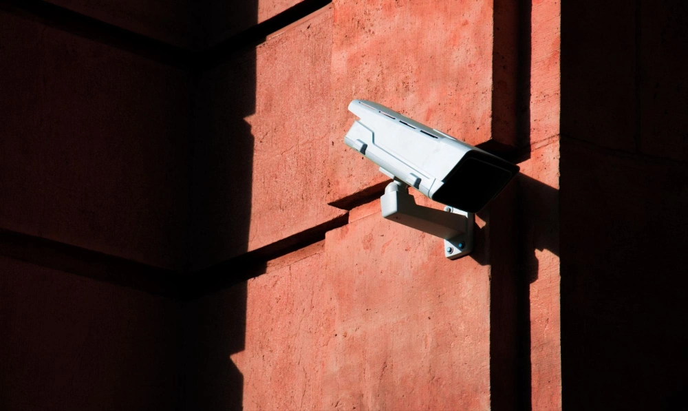Mounted surveillance camera on a commercial building wall, enhancing property security and monitoring