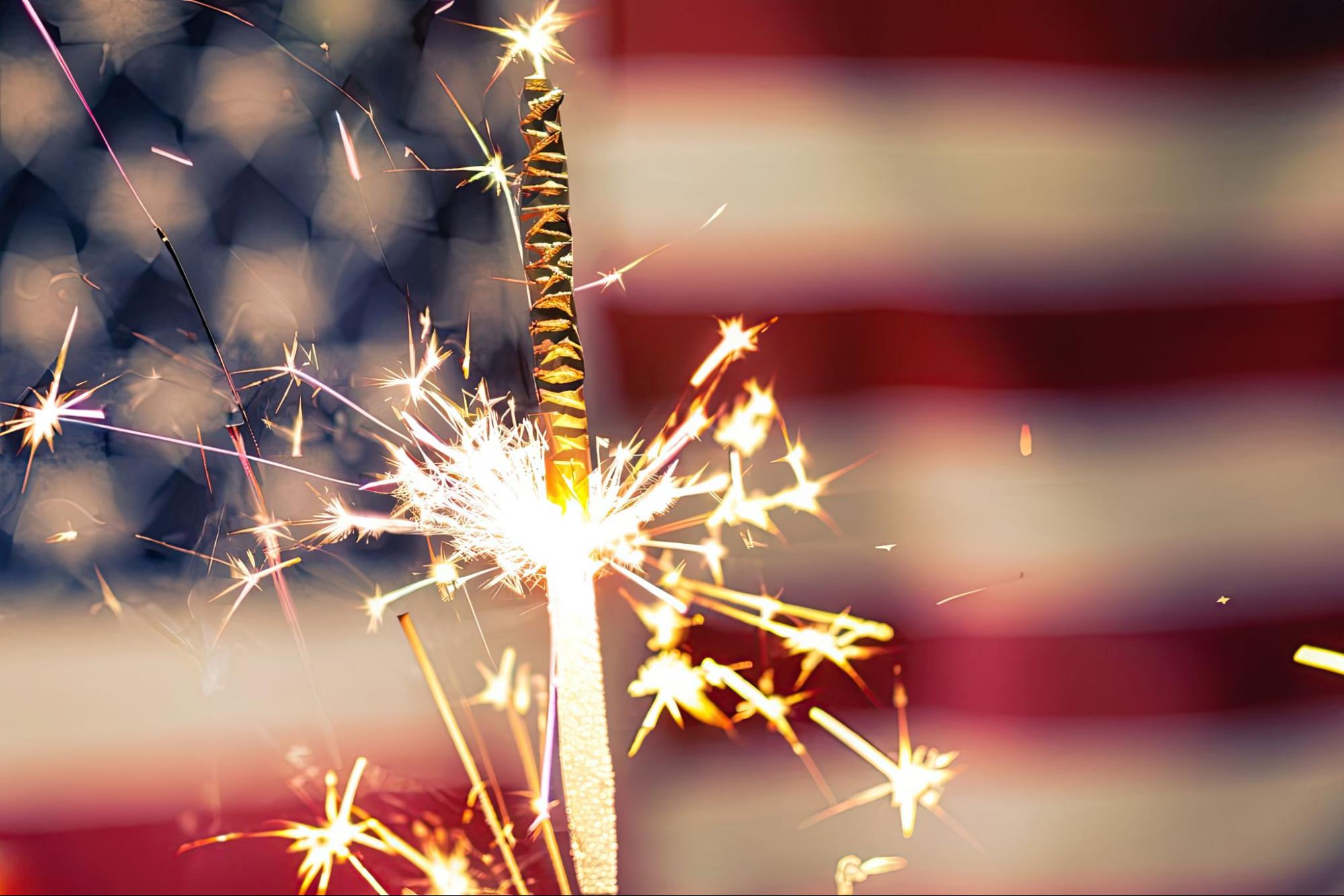 Fourth of July sparkler in front of an American flag representing event security services by American Security Force